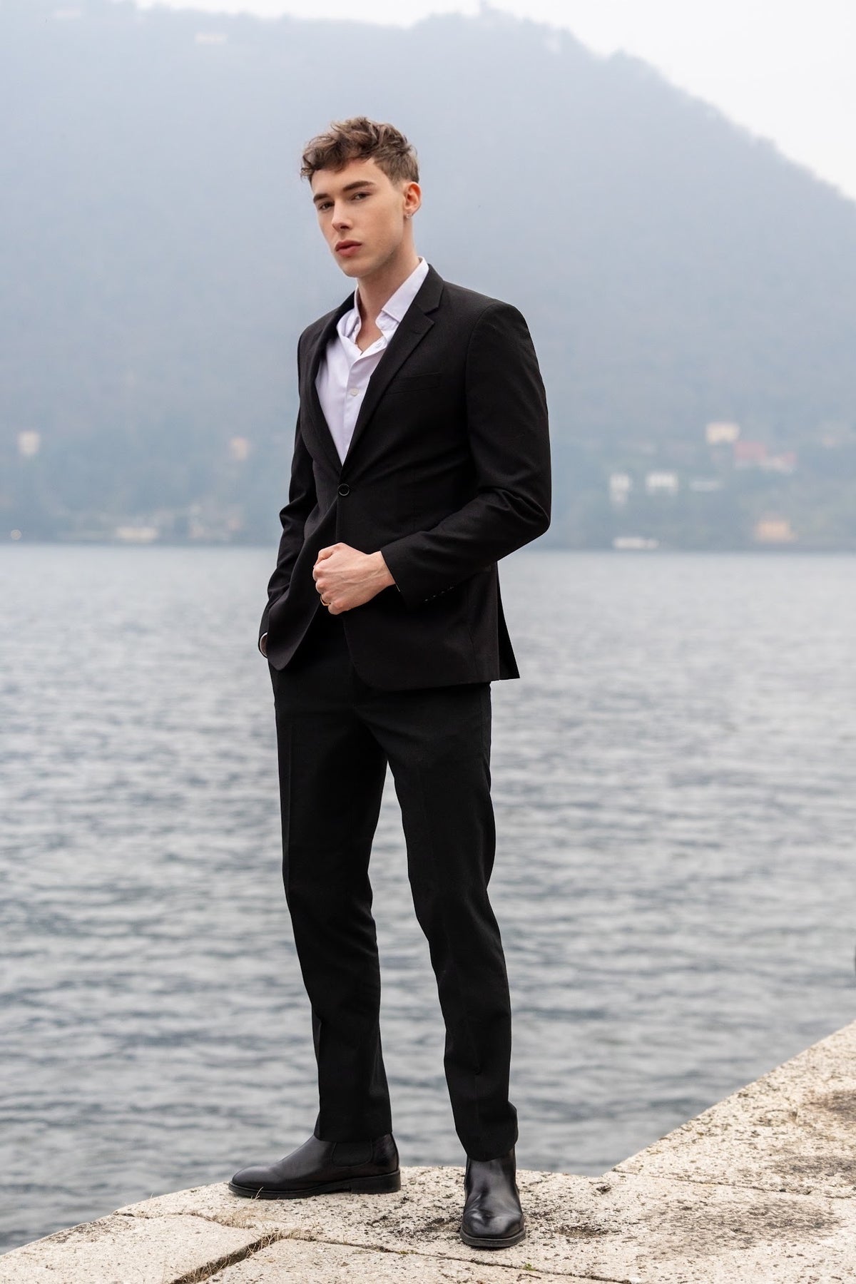 Clément Rudnicki en costume noir au bord du lac.